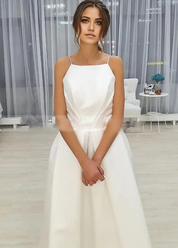Vestido de novia sencillo de corte A, sin mangas, con tirantes finos, espalda abierta, largo hasta la rodilla y bolsillos